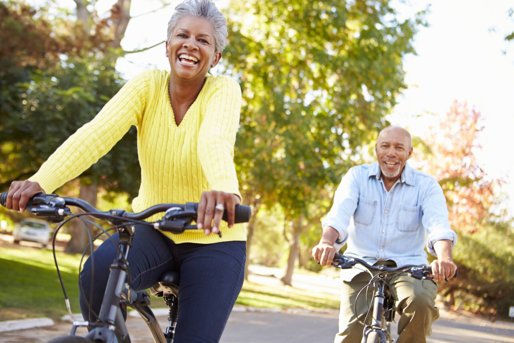 happy elderly couple riding bikes
